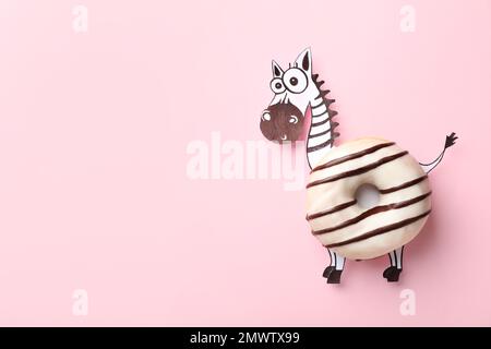 Funny zebra made with donut and piece of paper on pink background, top view. Space for text Stock Photo