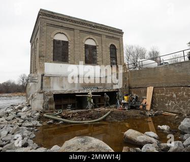 In this Thursday, Nov. 17, 2016 photo, workers close water intakes on a decommissioned hydroelectric powerhouse on the St. Regis River in Hogansburg, N.Y. A century after the first commercial dam was built on the St. Regis River, blocking the spawning runs of salmon and sturgeon, the river once central to the traditional culture of the Mohawk Tribe along New York's northern border is flowing freely again. (AP Photo/Mike Groll)