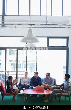 Explaining her vision. a group of office workers talking together in a meeting room. Stock Photo