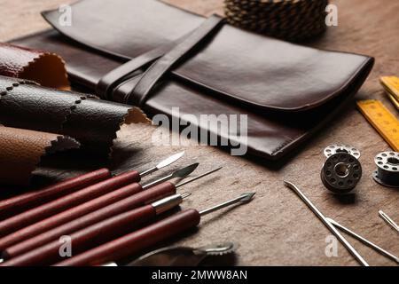 Leather samples and tools on brown table, closeup Stock Photo