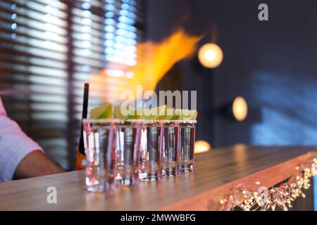 Mexican Tequila shots with lime slices on bar counter Stock Photo