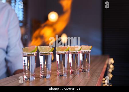 Mexican Tequila shots with lime slices on bar counter Stock Photo