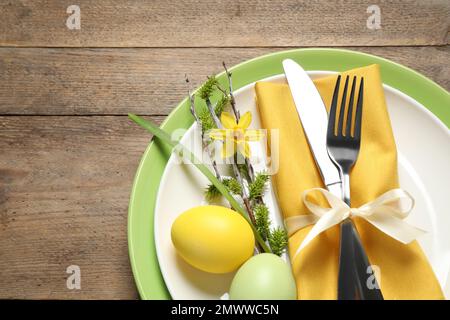 Festive Easter table setting with beautiful narcissus and painted eggs, top view Stock Photo