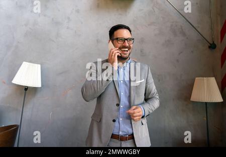 Portrait of young successful businessman with digital device working in corporate business office Stock Photo