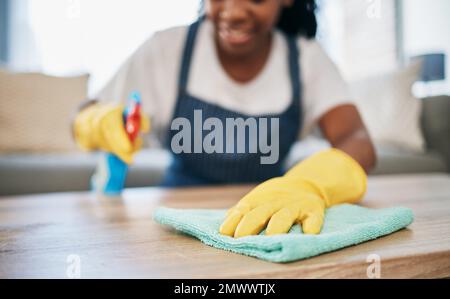 Hand, cloth and gloves with a black woman cleaning a home for hygiene as a housekeeper or maid. Furniture, bacteria and chemical with a female cleaner Stock Photo