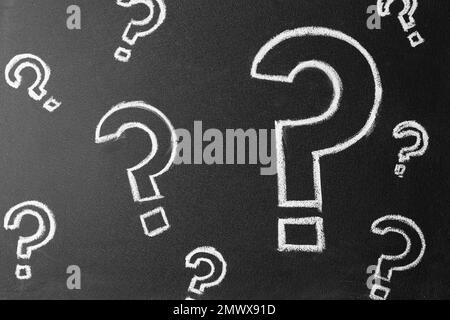Question marks drawn with chalk on blackboard, top view Stock Photo