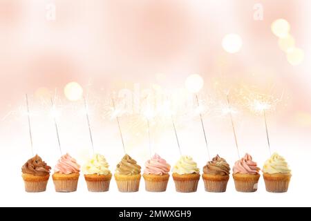 Birthday cupcakes with sparklers on light background Stock Photo