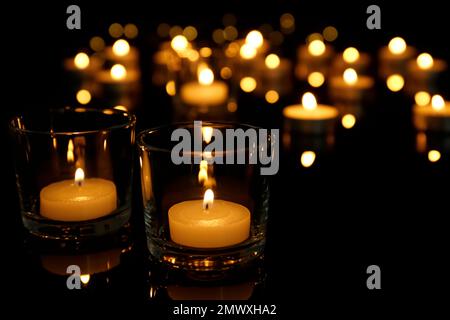 Burning candles in glass holders on table Stock Photo