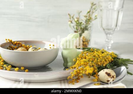 Festive Easter table setting with beautiful mimosa flowers Stock Photo