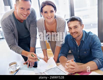 They know what theyre doing. Portrait of three coworkers going through paperwork together. Stock Photo