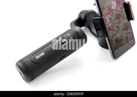 London. UK- 02.01.2023. A Zhiyun handheld gimbal stabilizer with a smart phone attached isolated in white. Stock Photo