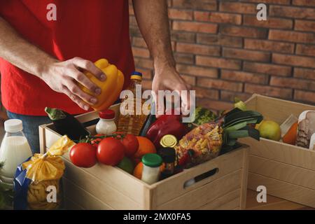 Man with fresh products at table indoors, closeup. Food delivery service Stock Photo