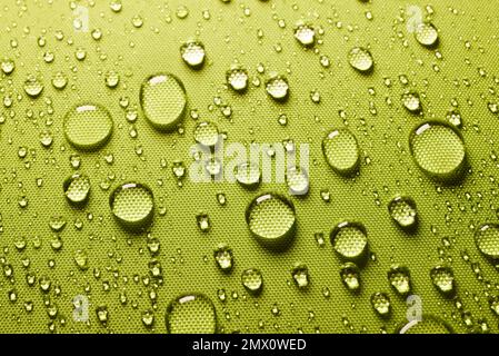 High angle green background with closeup textile drops of water on wet textile laminated with waterproof surface in light room Stock Photo