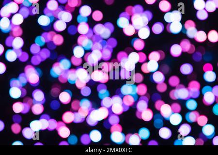 Abstract backdrop of blurred magenta and blue confetti on a black background with bokeh light effect Stock Photo