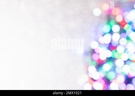 Blurred coloured confetti of lights on a sparkling white background with copy space Stock Photo