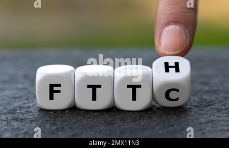 Hand turns dice and changes the expression Fiber to the curb (FTTC) to Fiber to the home (FTTH). Symbol for connecting residences directly with optica Stock Photo