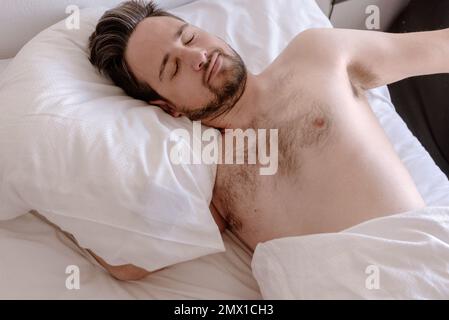 Man sleeping peacefully lying on bed Stock Photo
