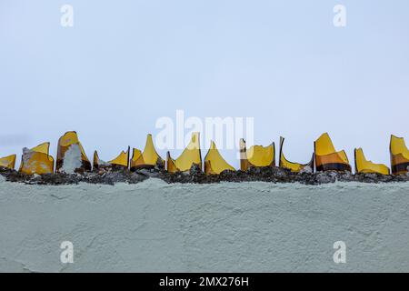 View of broken glass shards on wall for prevention of burglary. Stock Photo