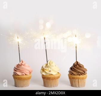 Birthday cupcakes with sparklers on white background Stock Photo