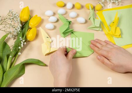 Handicrafts from paper for Easter - origami, making figurines of Easter bunnies, hands close-up Stock Photo