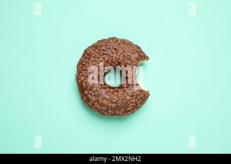 Delicious glazed donut on turquoise background, top view Stock Photo