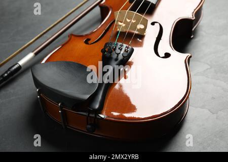 Classic violin and bow on grey stone background, closeup Stock Photo