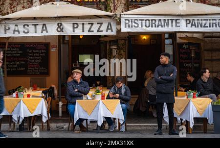 adult couple sitting making an aperitif in a typical traditional Roman restaurant, city life concept Stock Photo