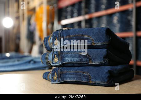 Stack of stylish jeans on display in shop Stock Photo