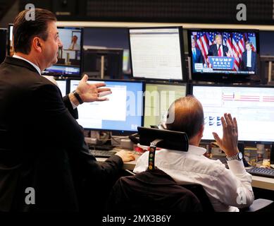 Brokers react as newly elected US President Donald Trump shows up on a television screen at the stock market in Frankfurt, Germany, Wednesday, Nov. 9, 2016.(AP Photo/Michael Probst)