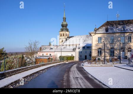 Europe, Luxembourg, Koerich, Views of Église Saint-Remi (Church of Saint Remi) from Neie Wée in Winter Snow Stock Photo