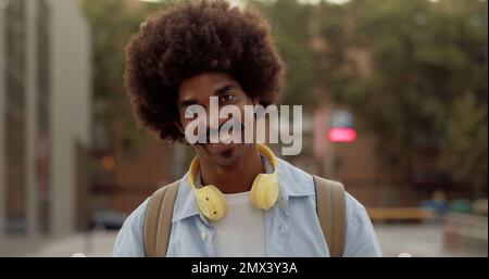 Portrait of a funky smiling young african american man looking at camera in a city at night Stock Photo