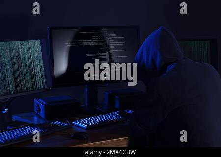 Hacker with computers in dark room. Cyber crime Stock Photo