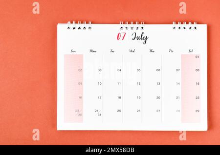 July 2023 calendar desk for the organizer to plan and reminder on red background. Stock Photo
