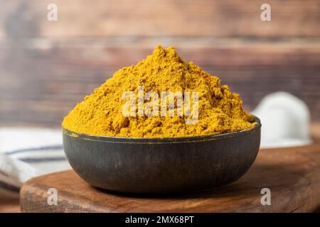 Curry Masala Powder. Turmeric powder or curry powder spice in a bowl on wooden background. İndian spices. Dry spice concept. close up Stock Photo