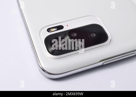 Smartphone quad camera module. New modern white smartphone with quad camera module isolated on white background. Closeup of smartphone camera lens Stock Photo