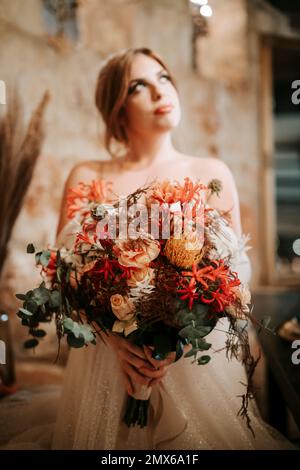 Portrait of beautiful bride with a bouquet in rustic settings Stock Photo