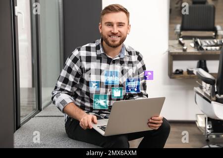 Young man using laptop in barber shop. Online shopping Stock Photo