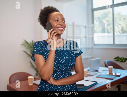 Young Black business woman talks on cellphone in boardroom smiling Stock Photo