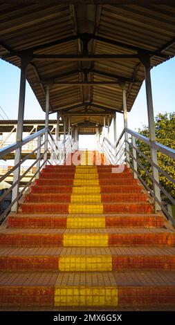 Railway station foot over staircase goes to Foot over bridge, inside view of station corridor, staircase of a foot over bridge at a rural railway stat Stock Photo