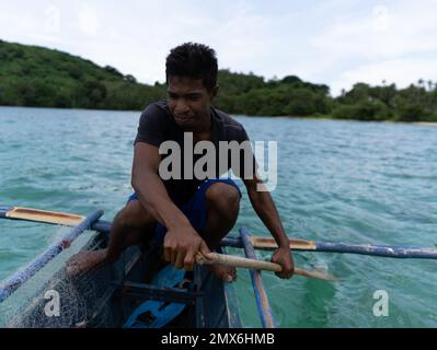Young asian fishermen rowing on a boat in a tropical sea, philippines islands Stock Photo