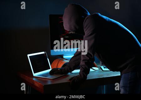 Hacker with computers in dark room. Cyber crime Stock Photo