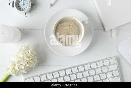 Flat lay composition with keyboard, coffee and flower on white wooden table Stock Photo