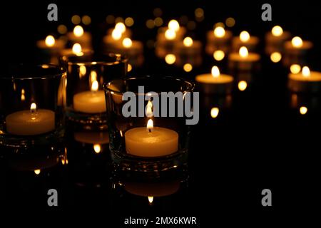 Burning candles in glass holders on table Stock Photo