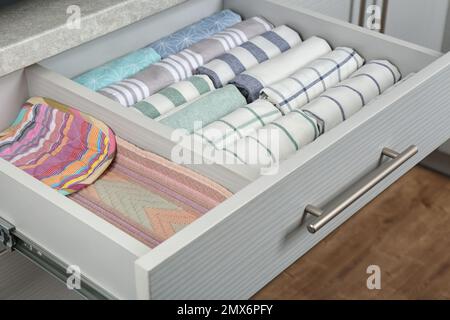 Open drawer with folded towels. Order in kitchen Stock Photo