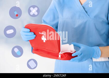 Doctor in medical gloves with first aid kit on blurred background Stock Photo