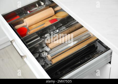 Different utensils in open desk drawer indoors Stock Photo