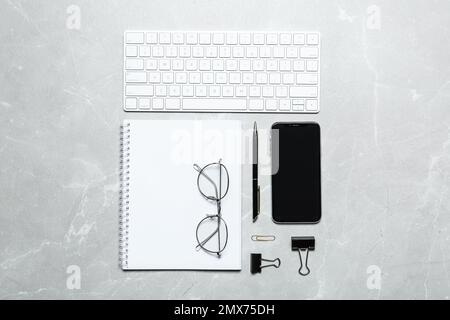Flat lay composition with computer keyboard and smartphone on marble background Stock Photo
