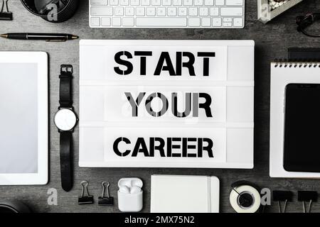 Flat lay composition with different devices and phrase START YOUR CAREER on grey stone background Stock Photo