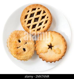 Three types of all butter mince pies on white ceramic plate isolated on white. Top view. Stock Photo