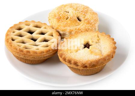 Three types of all butter mince pies on white ceramic plate isolated on white. Stock Photo